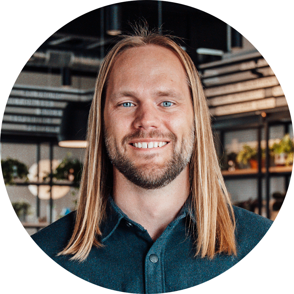 professional headshot of Isak, smiling at the camera and wearing a blue shirt.